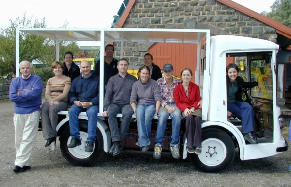 Mick Harris, circa 2003 with staff and volunteers and the electric milk float used to haul the bluestone workshop